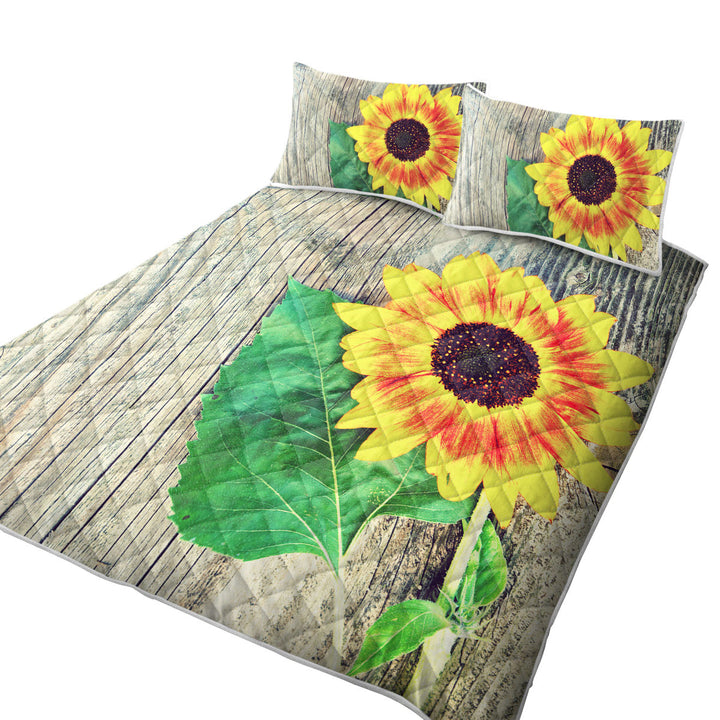 Quilt with Single Sunflower over Wooden Deck