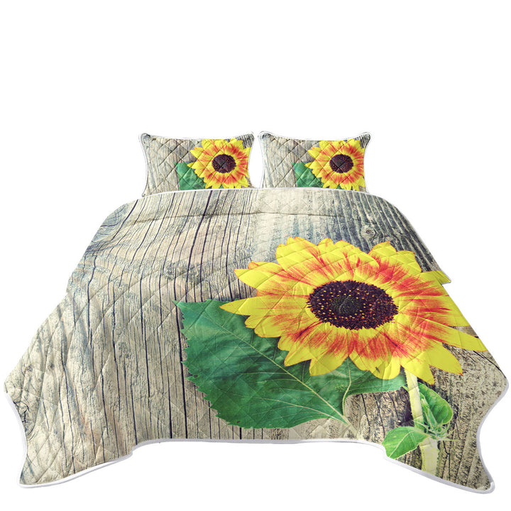 Twin Quilt with Single Sunflower over Wooden Deck